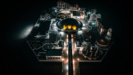 Aerial view of a seaside, Brighton Pier and beach in night lights, Brighton, East Sussex, UK