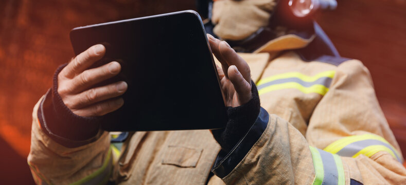 Fireman inspector conducts investigation to determine circumstances of fire in house and uses computer tablet for report incident. Concept Insurance payments and checklist