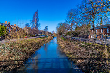 A view along the River Welland opposite Welland Place in the centre of Spalding, Lincolnshire on a bright sunny day