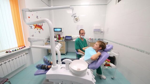 Dentist is putting rug to little boy at Children clinic 