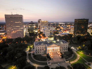 The Columbia, SC statehouse and skyline is seen in South Carolina after sunset in downtown. 