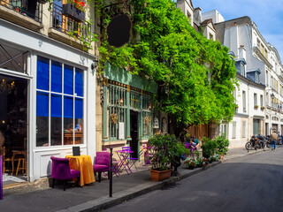 Fototapeta premium Typical view of street with tables of cafe in Paris, France. Cozy cityscape of Paris. Architecture and landmarks of Paris.
