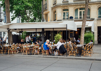 Typical view of the Parisian street with tables of brasserie (cafe) in Paris, France. Cozy cityscape of Paris. Architecture and landmarks of Paris. - 722416360