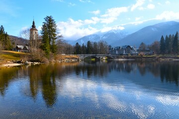 View of Bohinj lake and the arched bridge and the cloud covered mountains in Gorenjska, Slovenia