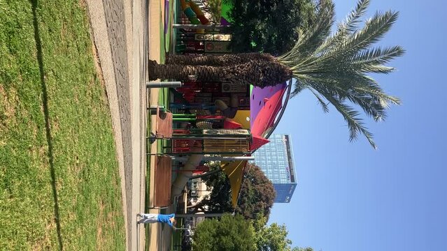 Boy paly on park. Reels vertical Beautiful bright children's playground. Fairytale castle, tunnels and slides for children. Kindergarten, walk in the park. Multi-colored sun awning,