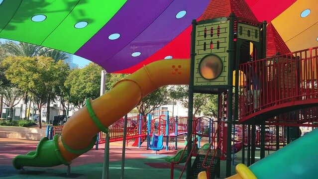 Boy paly on park. Beautiful bright children's playground. Fairytale castle, tunnels and slides for children. Kindergarten, walk in the park. Multi-colored sun awning,