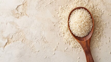Grains of white rice in wooden spoon on white textured background. Top view. Banner with copy...