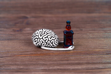 Steel Brain Holds Whiskey Bottle on Wooden Background