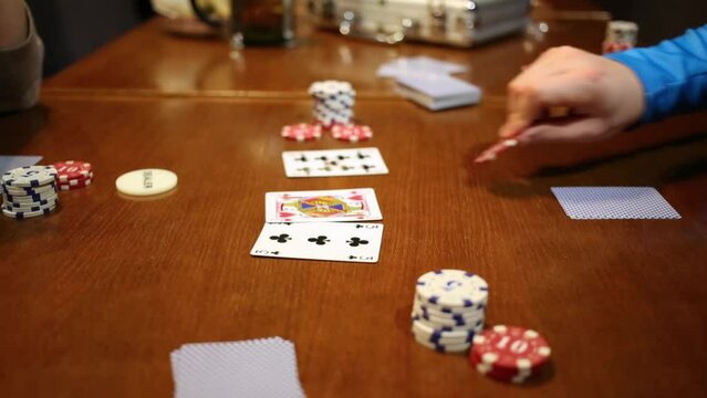 Table with card, fish and woman and man hand playing poker close up