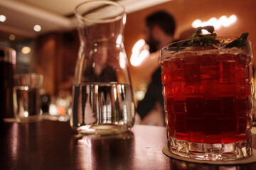 A Mint-Garnished red Cocktail at the Bar.