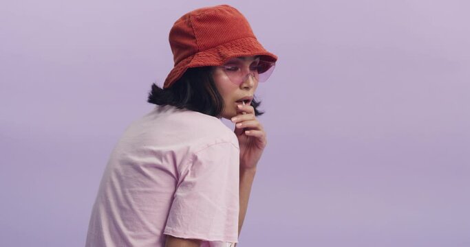 Cool, fashion and woman with a lollipop or candy in studio, purple background and mock up space. Gen z, style and portrait of model with streetwear eating sweets with confidence, pride and attitude