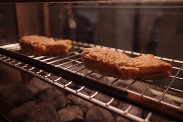 Taiyaki , Fish-shaped pastry are heated in stone oven. 