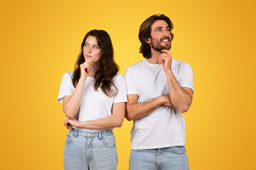 Thoughtful couple in white t-shirts, with the man and woman looking upwards with hand on chin
