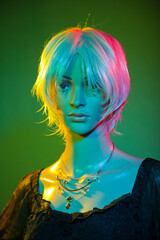 Mannequin wearing short white hair posing in a colorful studio lighting