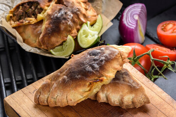 Close-Up of Homemade Fresh Beef Stuffed Empanada with Fresh Tomatoes - Appetizing 4K Ultra HD Image of Savory Pastry