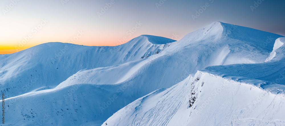 Sticker Snow-covered mountains illuminated by moonlight at blue hour.