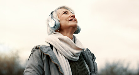 Headphones, music and senior woman in nature for wellness, mental health and happy outdoor...