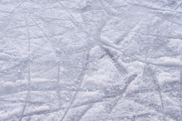 A detailed photo of an ice skating rink's scratched surface texture, showcasing the numerous skate scratches formed during winter activities.