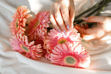 Beautiful woman with pink flowers on bed at home. St Valentine's Day. Women's day