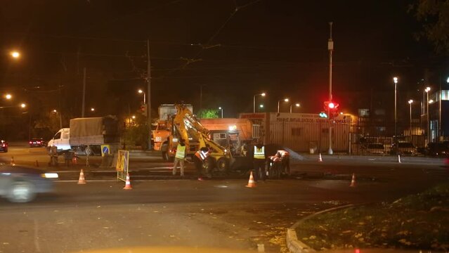 Workers lays asphalt on the tram rails at night. 