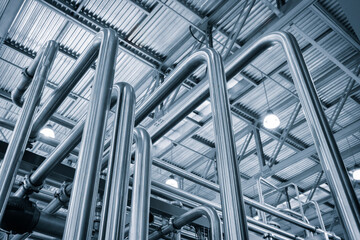 Metal pipes in an industrial building, view from bottom to top. Industrial concept background
