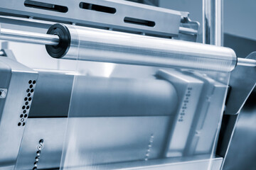 Automatic polyethylene plastic bag production machine with lighting effect. Close-up of the roller...