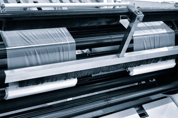 Automatic polyethylene plastic bag production machine with lighting effect. Close-up of the roller...
