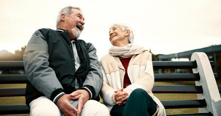 Retirement, laugh and Senior couple on bench at park with happiness or bond for quality time. Love, happy face and elderly woman or man in nature with support or embrace for trust or laugh together.