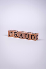 The inscription Fraud inspection made of wooden cubes on a plain background