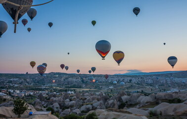 Hot air balloons flying over bizarre rock landscape in Cappadoci