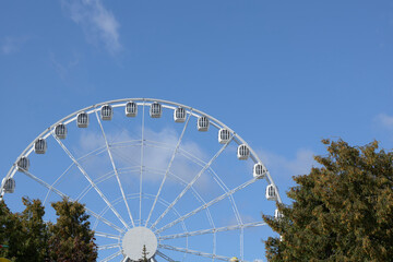 Fototapeta premium Celestial Carousel, A Majestic White Ferris Wheel Touching the Skies on a Radiant Day
