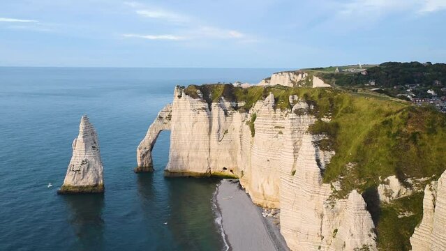 Etretat, Normandy, France. Cliffs Aval and Needle with beautiful famous coastline during the tide at sunset. Aerial view. Popular travel destination