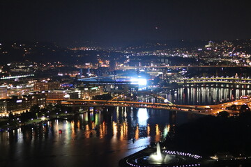Fototapeta na wymiar Downtown at night. View of the city lights and landscape. Panoramic view of the bridge and river in the downtown city of Pittsburgh, Pennsylvania —aerial, birds' eye view of downtown and river.