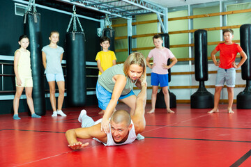 Children practice self-defense techniques on the coach