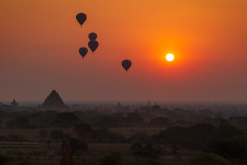 Scenic landscape of many ancient temples and pagodas and hot-air balloons over the plain of Bagan in Myanmar (Burma) at sunrise.