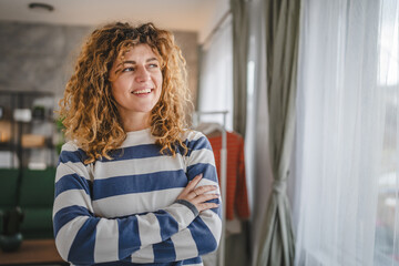 Portrait of adult caucasian woman with curly hair at home happy smile