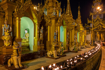 Many statues and pagodas at the Shwedagon Pagoda in Yangon, Myanmar at dusk.