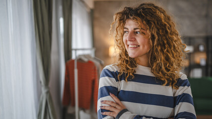 Portrait of adult caucasian woman with curly hair at home happy smile