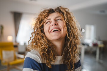Portrait of adult caucasian woman with curly hair at home happy smile - Powered by Adobe