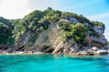 Obraz premium Scenic landscape of Island of Corfu, Greece, western shoreline with cliffs and caves at beach and water line of turquoise or deep blue water with breath taking limestone formations