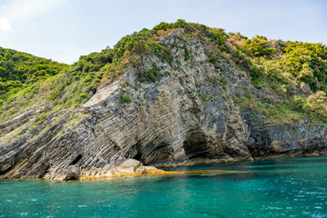 Obraz premium Scenic landscape of Island of Corfu, Greece, western shoreline with cliffs and caves at beach and water line of turquoise or deep blue water with breath taking limestone formations