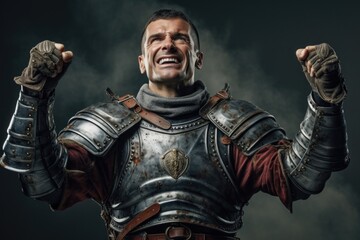 Fototapeta premium A powerful image of a man in armor raising his fist in a show of strength and determination. This picture can be used to convey concepts of courage, leadership, defiance, and determination.