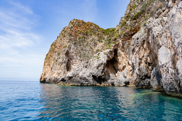 Obraz premium Scenic landscape of Island of Corfu, Greece, western shoreline with cliffs and caves at beach and water line of turquoise or deep blue water with breath taking limestone formations