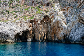Scenic landscape of Island of Corfu, Greece, western shoreline with cliffs and caves at beach and water line of turquoise or deep blue water with breath taking limestone formations
