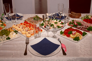 The banquet is festive, beautiful table setting, a table with very tasty meat and fish dishes.