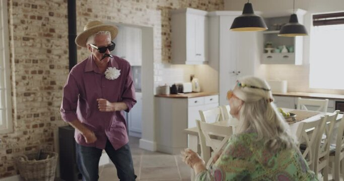 Dance, comic and a fun senior couple in the house for comedy, crazy and humor together. Happy, excited and a man and woman in retirement being funny, laughing and bonding with music and goofy