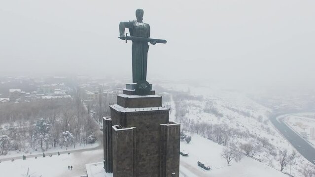 City panorama and Mother Armenia monument during snow fall