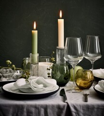  a close up of a table with wine glasses and a plate with a candle in the middle of the table.