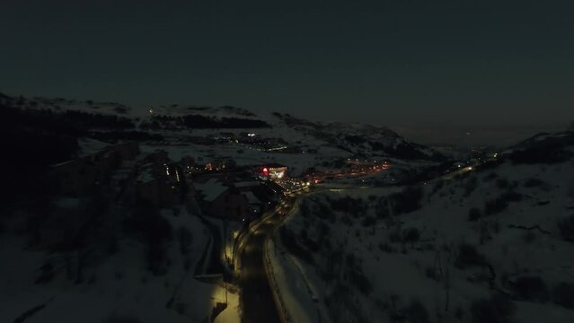 Cars ride near illuminated complex of Marriott hotel among mountains 