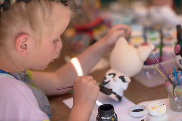 Girls 4-5 years old are sitting at a table and painting with colorful paints. Children's creativity. Children's hobbies.